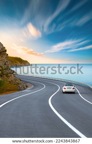 road landscape in summer. car driving on the road of europe. Highway scenery in beautiful nature. A white car on the road against the backdrop of a blue seascape. highway landscape on the ocean beach. Royalty-Free Stock Photo #2243843867