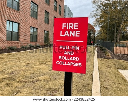 a red fire lane sign near some building 