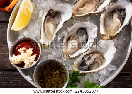 A top down view of a platter of raw oysters.