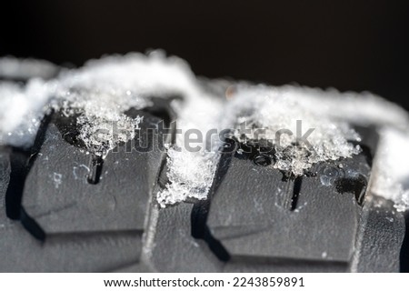 Closeup selective focus on snow packed in an all-weather tire tread.