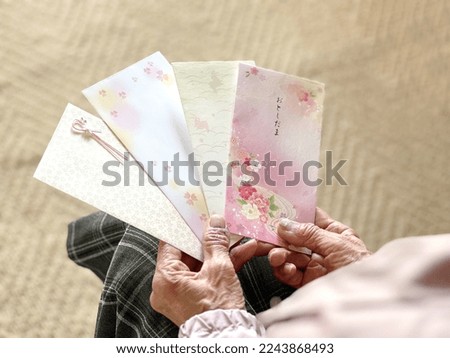 Elderly woman's hand holding a pension book.
Japanese means New Year's gift money.