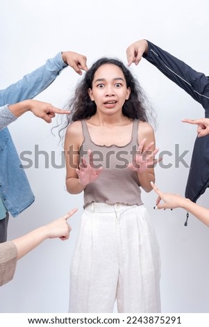 A scared young lady being blamed. Arms from anonymous people implicating her. Accusation and trial concept. Court of public opinion. Royalty-Free Stock Photo #2243875291