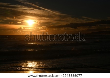 Sunset on the beach with waves in Coma-Ruga, the province of Tarragona, Spain