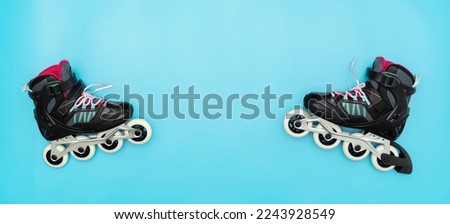 Stylish roller skates on blue background, top view. Inline skates isolated on blue, extreme sports background