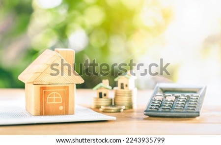 close up house's model on banking account book with calculator, House placed on coins on table for planning of home loan mortgage refinance or retention interest rates, business and financial concept. Royalty-Free Stock Photo #2243935799