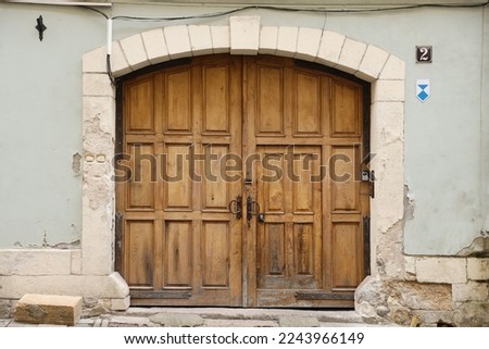 Old ancient wooden door texture in european medieval style. The detailed texture of closed brown aged door from weathered and stained wooden planks and boards