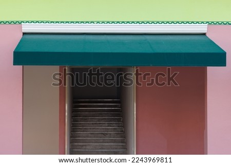 green awning over the entrance door. green canvas roof for sun protection. exterior roof shading. Royalty-Free Stock Photo #2243969811