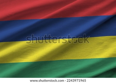 Mauritius flag with big folds waving close up under the studio light indoors. The official symbols and colors in fabric banner