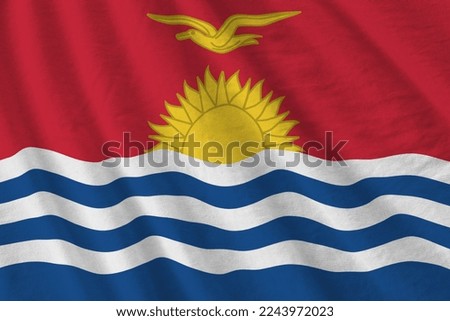 Kiribati flag with big folds waving close up under the studio light indoors. The official symbols and colors in fabric banner