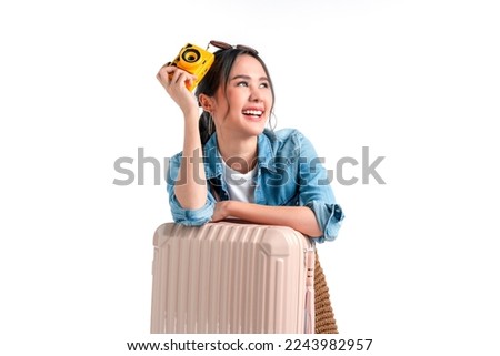 ready to travel ,young teen asian smiling cheerful female woman casual cloth hand hold camera standing with luggage case bag prepare to new abroad journey travel studio shot on white background  Royalty-Free Stock Photo #2243982957