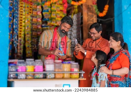 Indian rural customer using smartphone for digital payment at groceries shop Royalty-Free Stock Photo #2243984885