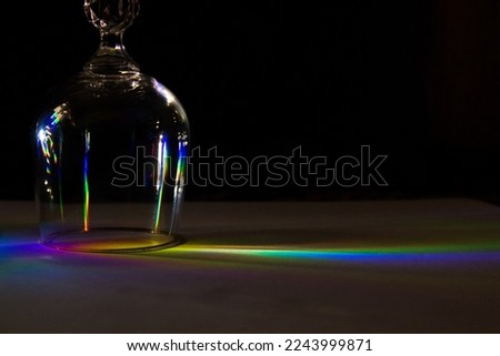 A picture of glass cups on white paper, and the appearance of shadows resulting from them due to sunlight, as well as the phenomenon of decomposition of white light into seven colors.