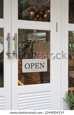 Open sign board hanging on door of cafe.