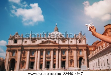 Closeup toy airplane on St. Peter's Basilica church in Vatican city background. Concept of travel imagination
