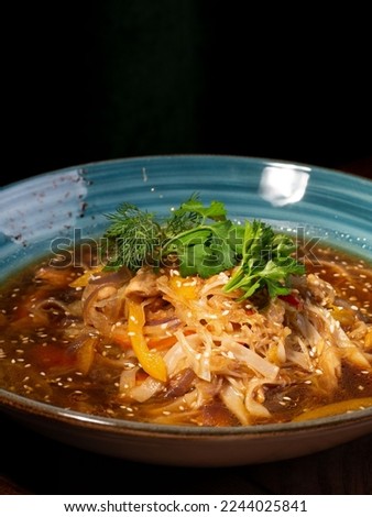 Chicken noodles soup. Asia food on blue plate on black