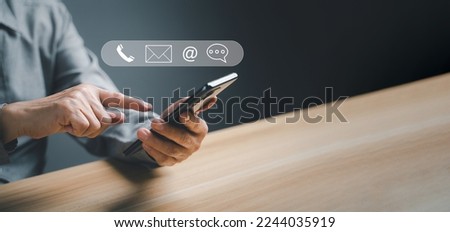 Contact us, Concept of business communication. Businessman using and mobile smartphone to connect to customer support online internet with ( phone, email ) icon. customer support concept, copy space. Royalty-Free Stock Photo #2244035919