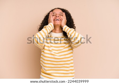 Young african american curly woman isolated laughs joyfully keeping hands on head. Happiness concept.