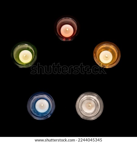 Tea lights with the colors of the 5 elements. Red (fire), yellow (earth), white (metal), blue (water) and green (wood). The 5 elements come from Chinese teachings. Royalty-Free Stock Photo #2244045345