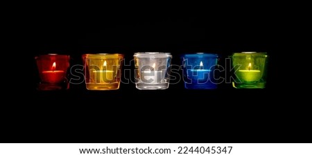 Tea lights with the colors of the 5 elements. Red (fire), yellow (earth), white (metal), blue (water) and green (wood). The 5 elements come from Chinese teachings. Royalty-Free Stock Photo #2244045347