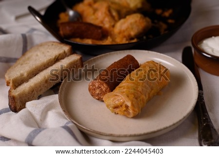 Stuffed cabbage rolls with meat and sausage on a plate.