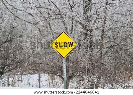 Slow down sign on winter road