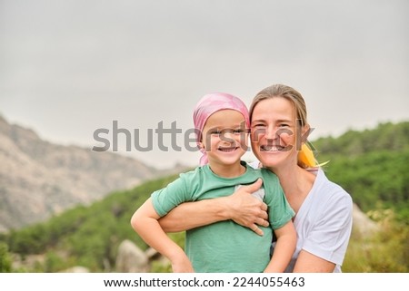 Portrait of a nurse with a child with cancer in nature