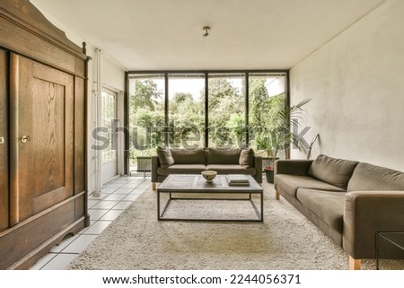 a living room with couches, coffee table and sliding glass doors leading to the outside patio area that overlooks