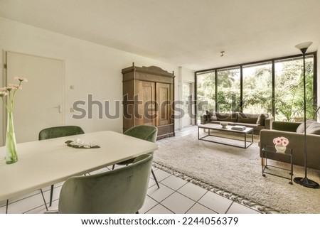 a living room with couches, chairs and a table in front of a sliding glass door that opens onto the patio