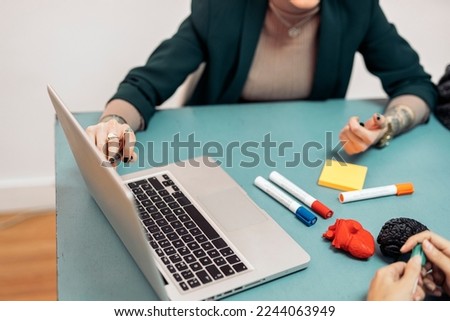 Business women during brainstorming process in 3d printing business using laptop.