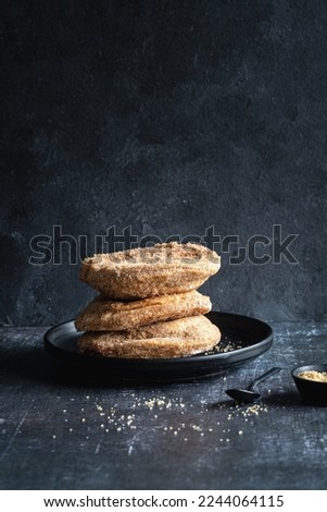 A stack of three apple beignets (apple fritters) on black background, no people,, vertical