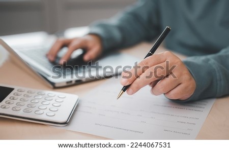 US IRS 1040 form or  US Individual income tax Concept,accountant holding pen working on calculator business with data accounting documents and a laptop, pay tax in 2023 years,new year 2023 tax concept Royalty-Free Stock Photo #2244067531