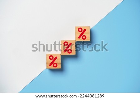 Red percentage sign print screen on wooden cube block on white and blue background for increase financial interest rate and business investment growth from dividend concept.