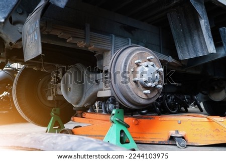 the truck axle is held in place by jacks and jack stands Royalty-Free Stock Photo #2244103975