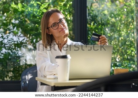 Young woman holding credit card and using laptop computer. Businesswoman working at home. Online shopping, e-commerce, internet banking, spending money, working from home concept. High quality photo