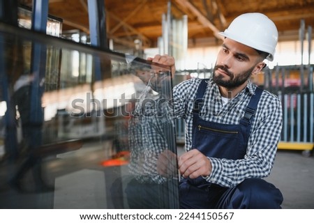 the glazier takes a piece of mirror off the table. Glass factory, manufacture. Royalty-Free Stock Photo #2244150567