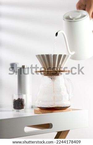 Pouring hot water through coffee grounds in a filter Royalty-Free Stock Photo #2244178409