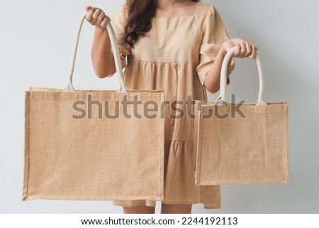Woman holding  jute bag or sack bag on white background. Reusable shopping bag. Natural material. Zero waste. Plastic free. Eco friendly concept.