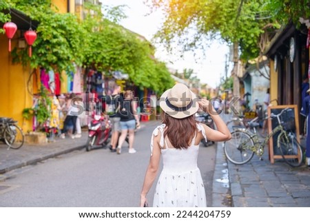 happy traveler sightseeing at Hoi An ancient town in central Vietnam, woman with dress and hat traveling. landmark and popular for tourist attractions. Vietnam and Southeast Asia travel concept