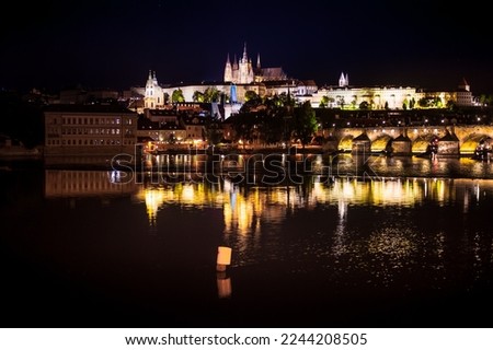 perspective to a castle of the night prague at dusk from the side of the Vltava Rive