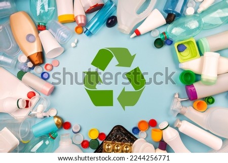 Separate collection of plastic garbage. PET, PP, HDPE, LDPE stuff for recycle on blue background. Eco friendly concept. Recyclable plastic waste:  bottles, containers, disposable cups, bottle caps Royalty-Free Stock Photo #2244256771