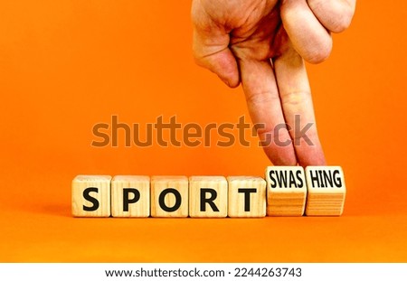 Sport or sportswashing symbol. Concept words Sport and Sportswashing on wooden cubes. Businessman hand. Beautiful orange table orange background. Business sport sportswashing concept. Copy space.