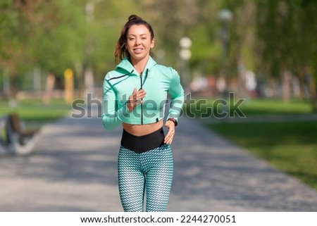 Picture of a woman running in park in early morning. Attractive looking woman keeping fit and healthy. Healthy lifestyle concept.