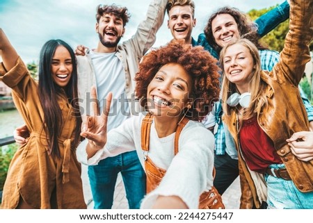 Happy multiracial friends taking selfie picture outside - Group of young people smiling together at camera outdoors - Teenagers having fun walking on city street - Youth culture and friendship concept