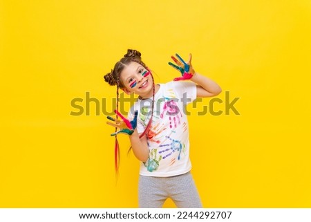 Art drawing for children. A small smiling girl on a yellow isolated background . The child got his hands dirty in paint. Drawing courses for children. Royalty-Free Stock Photo #2244292707