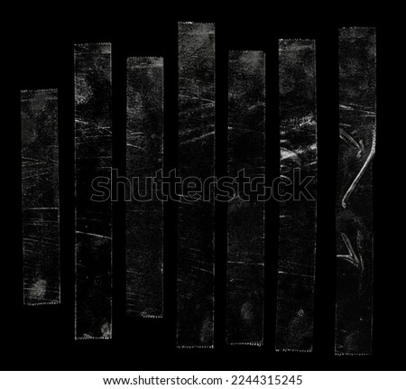 set of transparent adhesive tape or glue strips isolated on black background, crumpled plastic sticky snips, real macro photo. Royalty-Free Stock Photo #2244315245