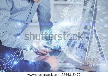 Technology theme hologram with man working on computer on background. High tech concept. Multi exposure.
