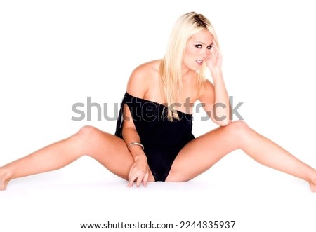 An attractive blonde model poses in a studio environment
