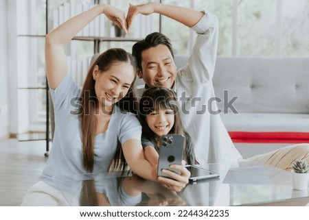 Happy young asian family father mother making hands shape heart taking selfie photo with little cute daughter at home Royalty-Free Stock Photo #2244342235