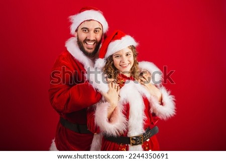 Brazilian couple, dressed in Christmas clothes, Santa Claus, hugging