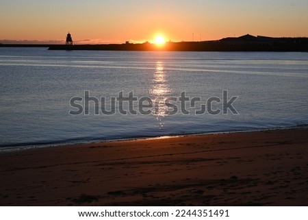Winter sunrise over mouth of River Tyne on calm morning, photographed from quayside at North Shields, England